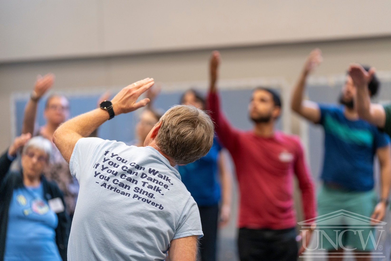 A group of people raising their hands
Description automatically generated